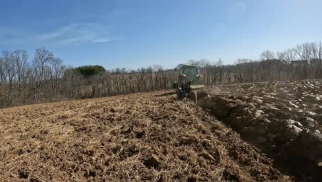 Ein-John-Deere-Traktor-Mit-Angebautem-Lader-Schleppt-Einen-Pflug,-Um-Den-Boden-Umzugraben,-Als-Ersten-Schritt-Bei-Der-Vorbereitung-Des-Feldes-Für-Die-Neubepflanzung-Mit-Luzerne