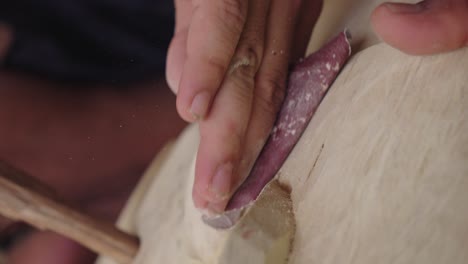 Carver's-Hands-Using-Sandpaper,-Barong-Mask-Carving-Process-In-Bali,-Indonesia---Close-Up