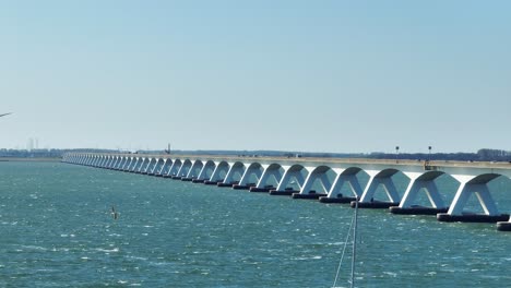 Long-lens-drone-shot-of-the-famous-Zeeland-bridge-during-a-sunny-day