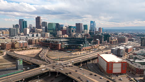 Vista-De-Hiperlapso-De-Drones-Del-Flujo-De-Tráfico-Alrededor-De-Coors-Field,-Horizonte-De-Denver-En-La-Parte-Posterior