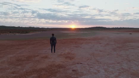 Drone-clip-moving-forward-past-male-model-towards-beautiful-sunrise-over-colourful-Australian-outback
