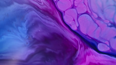 Vibrant-ink-swirling-in-water,-creating-an-abstract-pattern-of-purple-and-blue-hues