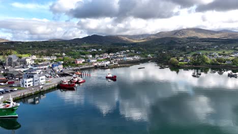 Drohnen-Landschaftsboot-Verlässt-Den-Hafen-Von-Castletownbere,-Irland,-Am-Frühen-Sommermorgen-Mit-Den-Hügeln-Von-West-Cork-Im-Hintergrund