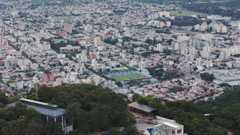 Tracking-Aerial-Of-Mountain-House-Over-Salta-Capital-City-Football-Stadium-Estadio-el-Gigante-del-Norte
