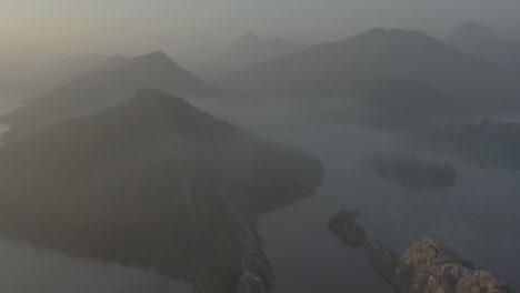 Aerial-drone-view-showing-lots-of-big-mountains-and-lots-of-bushes-and-lots-of-water-around