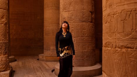 Woman-admiring-ancient-egyptian-hieroglyphs-on-pillars-inside-the-Philae-temple-complex