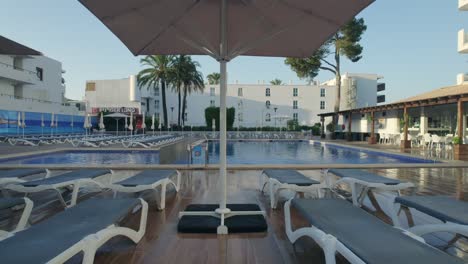 Drone-footage-of-swimming-pool-of-a-Globales-Lord-Nelson-hotel-in-Mallorca,-Spain-during-afternoon