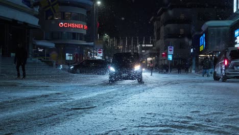 Toma-Nocturna-En-ángulo-Bajo-Que-Muestra-El-Tráfico-Que-Sale-Del-Centro-De-La-Ciudad-De-Davos.