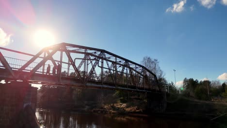 Sunrise-skyline-at-Latvian's-river,-people-cross-natural-environment-in-autumn