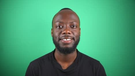 Black-Male-Smiling-In-Front-Of-Camera-With-Green-Screen