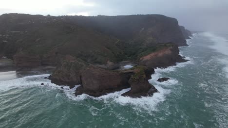 Luftaufnahme-Der-Insel-Taitomo-Und-Der-Tasmansee-Am-Frühen-Morgen-In-Piha-Beach,-Auckland,-Neuseeland