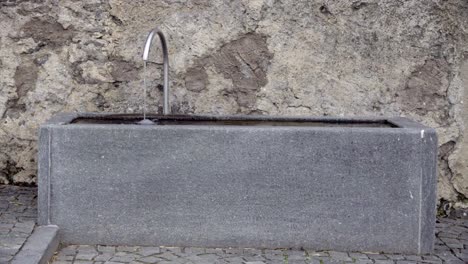 A-stone-fountain-in-the-village-of-Laatsch---Laudes,-South-Tyrol,-Italy