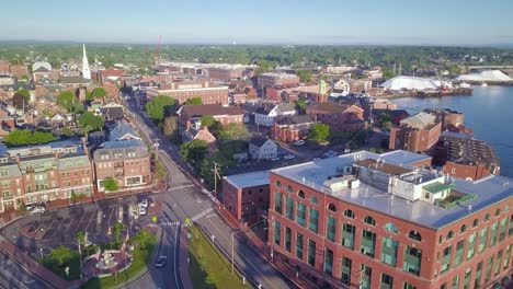 Drone-shot-pulling-back-from-downtown-Portsmouth,-NH-to-reveal-the-drawbridge-over-the-river