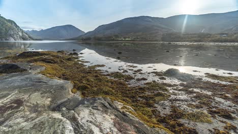 The-rising-tide-slowly-covers-the-sandy-bottom-and-reaches-for-the-rocky-shore-in-a-timelapse-video