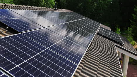 Drone-Volando-A-Lo-Largo-De-Un-Conjunto-De-Células-Solares,-Generando-Electricidad-En-El-Techo-De-Una-Casa