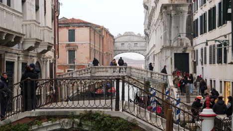 Puente-Ocupado-En-Venecia-Con-Turistas-Disfrutando-Del-Paisaje-Urbano-En-Un-Día-Nublado,-Gente-Cruzando