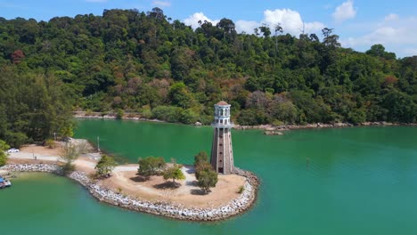 Solitary-lighthouse-on-headland-with-scenic-tropical-beach