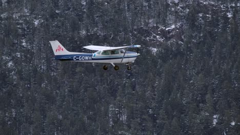 Propellerflugzeug-Fliegt-An-Einem-Wintertag-Gegen-Bewaldete-Berge