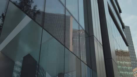 Pan-shot-of-Citibank-reflection-into-glass-building-in-Canary-Wharf,-London,-UK