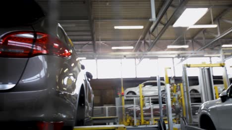 Luxury-car-in-automotive-plant-with-blurred-assembly-line-background,-indoors