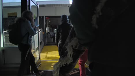 Pasajeros-Caminando-A-Través-De-Una-Puerta-Automática-De-Vidrio-Para-Embarcar-En-El-Ferry.