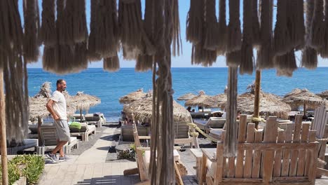 Man-walking-towards-a-beach-on-bright-daylight