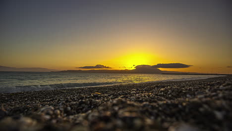 Sunrise-time-lapse-at-the-pebble-stone-beach-early-morning-sun-rising-transition