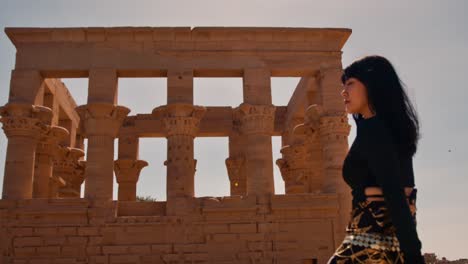 Happy-female-traveler-visiting-Trajan's-Kiosk-of-the-Philae-Temple-by-the-Nile,-Aswan,-Egypt
