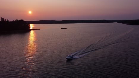 Barco-Hace-Olas-Por-Islas-En-El-Archipiélago-Del-Mar-Báltico-Al-Atardecer,-Antena-Estática