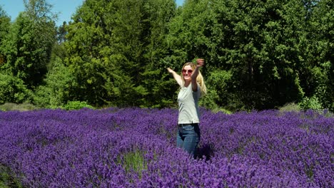 Happy-Young-Woman-In-Lavender-Field-In-Wanaka,-New-Zealand,-Turning-Around-With-Open-Arms-On-Sunny-Day