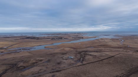 Río-En-Un-Paisaje-Llano-Marrón-En-Islandia-Bajo-Un-Cielo-Gris