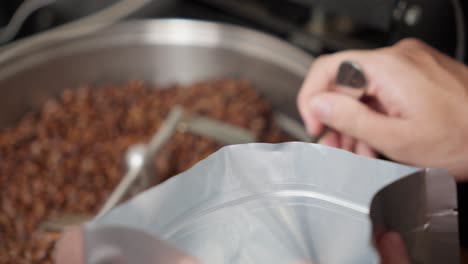 Llenar-Granos-De-Café-Tostados-En-Una-Bolsa-De-Aluminio-Con-Una-Cuchara-De-Acero-Inoxidable