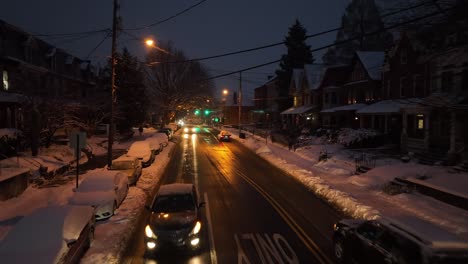 Niedrige-Luftaufnahme-über-Der-Karte,-Die-Nach-Einem-Schneesturm-Auf-Einer-Geräumten-Und-Gesalzenen-Straße-In-Einer-Amerikanischen-Stadt-Fährt