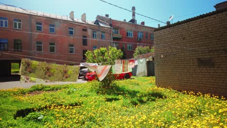 Ropa-Colorida-Colgada-Al-Aire-Libre-En-La-Ciudad-En-El-Campo-Con-Flores-Amarillas