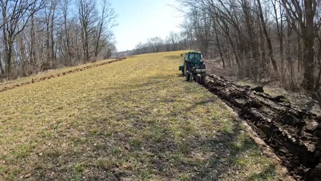 Following-a-John-Deere-tractor-plowing-a-field-to-prepare-soil-for-planting-in-early-spring-in-the-Midwest