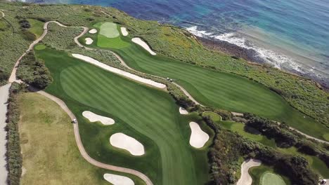 Aerial-View-of-Oceanfront-Golf-Course-in-Los-Angeles,-California-with-the-Pacific-Ocean-and-Crystal-Clear-Water-on-a-Warm,-Sunny-Day