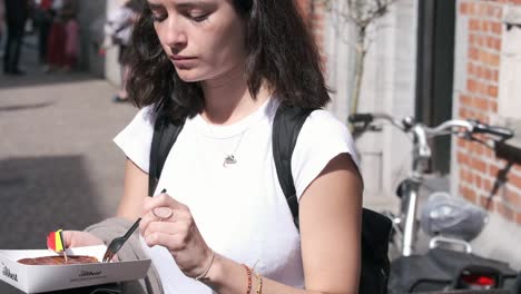 Woman-enjoys-Belgian-waffle-with-dark-chocolate-in-city