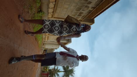 Geschwister-Gehen-Durch-Eine-Straße-In-Tansania---Vertikale-Aufnahme