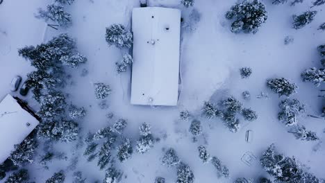 Top-down-drone-shot-above-cottages-in-Kiilopaa,-winter-in-Saariselka,-Finland