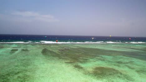Turquoise-waters-and-windsurfers-at-Los-Roques'-eastern-barrier,-vibrant-aquatic-scene