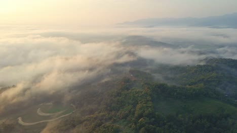 Eine-Drohne-Fliegt-Morgens-über-Eine-Tropische,-Von-Nebel-Eingehüllte-Landschaft