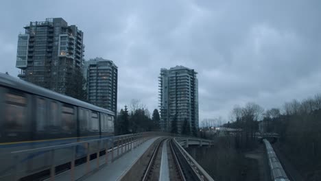 Puente-Ferroviario-Que-Pasa-Por-Edificios-De-Apartamentos-De-Gran-Altura-En-Vancouver,-Columbia-Británica,-Canadá.