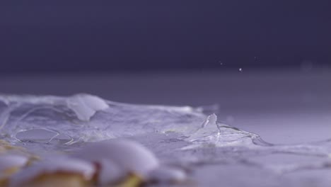 Close-up-of-a-shattered-egg-with-yolk-and-shell-fragments-splashing-in-super-slow-motion
