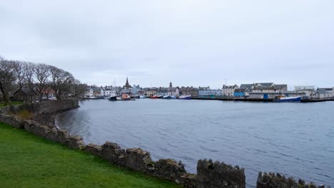 Scenic-view-overlooking-ocean-water-and-harbour-with-moored-ships,-boats,-and-waterfront-houses-in-Stornoway-town,-Outer-Hebrides,-Scotland-UK