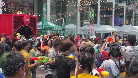 Scene-of-people-having-a-great-time-dancing-and-water-fighting-during-Songkran-Festival-at-Central-World,-Bangkok,-Thailand