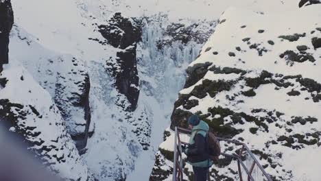 Turista-Explora-El-Punto-De-Vista-Del-Famoso-Cañón-Fjaðrárgljúfur,-Destino-De-Viaje-En-Islandia