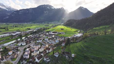 Sunset-over-Weesen,-Switzerland,-showcasing-a-village-nestled-between-lush-hills-and-mountains