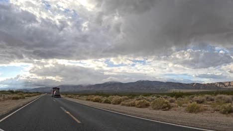 Leere-Autobahn-Mit-Blick-Auf-Die-Tehachapi-Berge-Unter-Einem-Stürmischen-Himmel,-Zeitraffer-Aus-Einem-Fahrenden-Fahrzeug