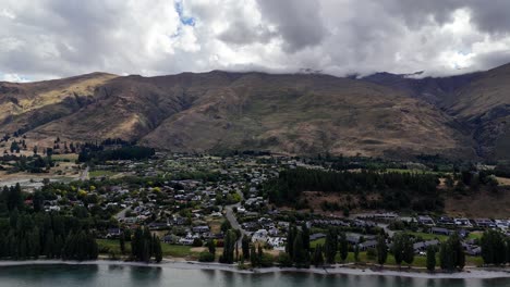 Vista-Aérea-De-Wanaka,-Nueva-Zelanda,-La-Belleza-Escénica-Las-Aguas-Serenas-Del-Lago-Se-Encuentran-Con-Una-Ciudad-Vibrante-Y-Exuberante