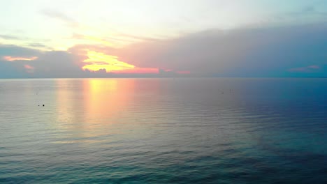 Aerial-drone-shot-over-the-ocean-sea-water-at-sunset